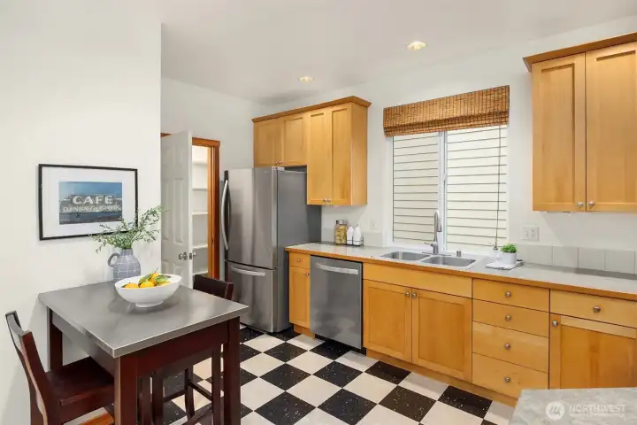 This bistro table doubles as a kitchen island for extra counter space.  Note the walk-in pantry next to the fridge.