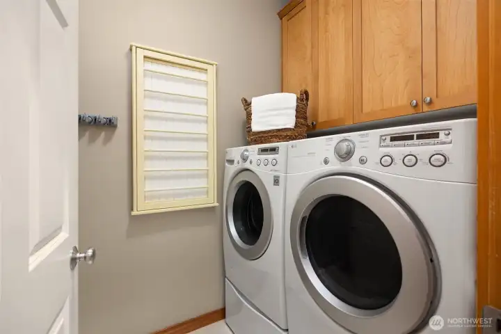 The laundry room features more storage and hanging racks.