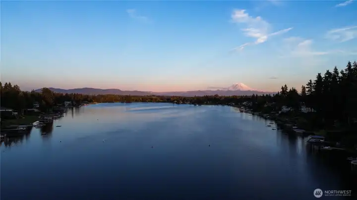 Lake Meridian is one of King County's most desirable lakes, one of the only in the county that permits motorized boating, jet skis, and seaplanes. This aerial showing Mt. Rainier captures exactly why people dream of living here, and why properties like this one almost never come available.