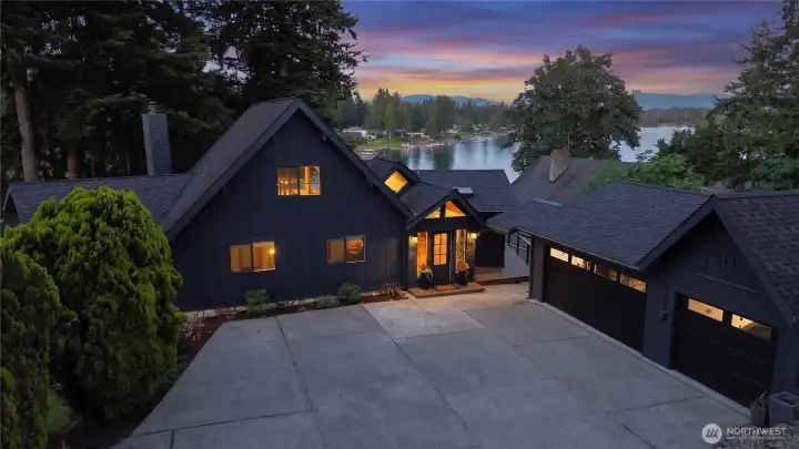 The dramatic A-frame roofline, four-car garage, and lakeside setting make this one of the most striking properties on the water. The 3-car garage is detached. An additional 1-car garage is attached on the left side of the home (not pictured).