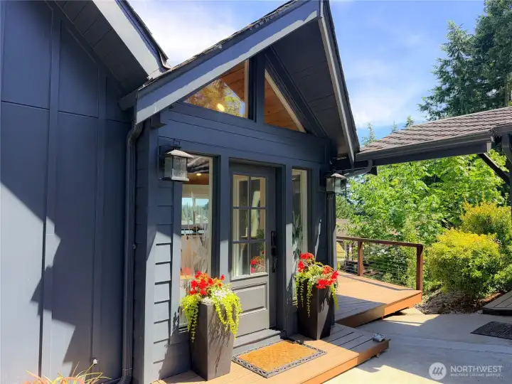 From the moment you arrive, this home makes a statement. The bold dark exterior, warm wood accents, and fresh blooms at the entry set the tone for everything inside.