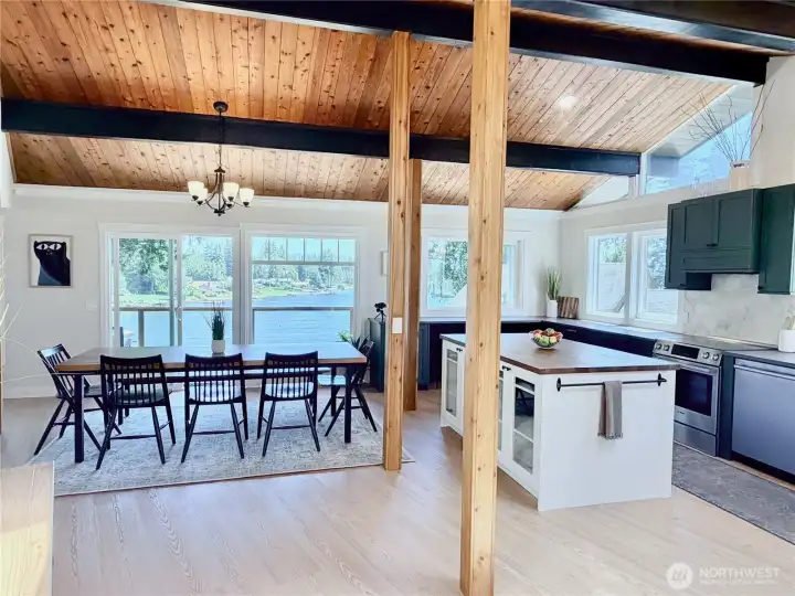 Open, airy, and flooded with light, the dining and kitchen area features gorgeous wood beam ceilings, a large island, and lake views from every angle. With two sliders opening onto the deck, entertaining here is effortless.