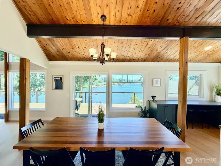 Imagine sitting down to dinner with this as your backdrop. The vaulted wood ceiling, exposed beams, and wall of windows frame Lake Meridian like a living painting.