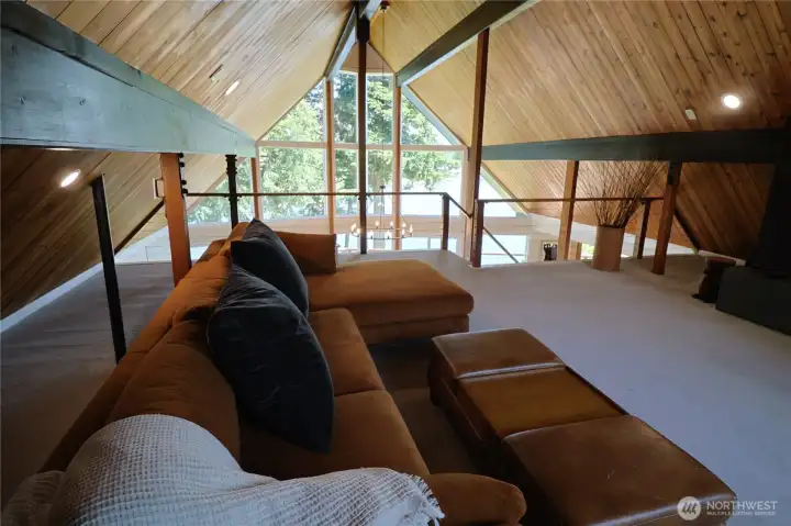 The stunning loft is unlike anything you have seen in a lake home. Soaring A-frame wood ceilings, exposed beams, and a dramatic wall of glass look directly out over Lake Meridian. Use it as a second living room, a reading retreat, or a media lounge. It earns its place in this home every single day.