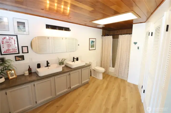 The lower level bathroom is spacious and updated with double vessel sinks, black hardware, wood-plank ceiling, a huge closet, a slider giving direct access to the patio and hot tub is, and a warm, eclectic personality. Guests will feel right at home here.