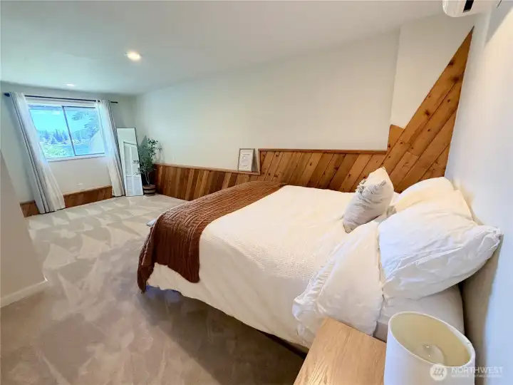 This lower level bedroom  with it's own mini-split for comfort, features a stunning custom wood accent wall and lake views, the kind of detail that makes this home feel special at every level. No HOA means short-term rentals are permitted.