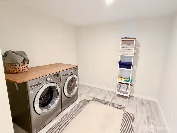 A generous dedicated laundry room with a full size front load washer and dryer, butcher block counter, and built-in shelving makes everyday living here as easy as it is beautiful. Both the washer and dryer convey.