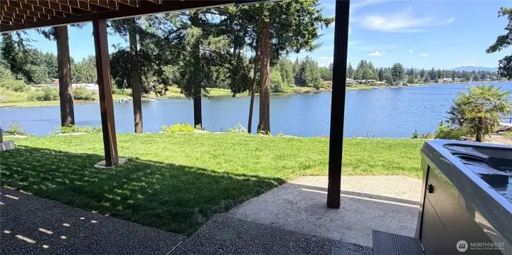 Step out from the daylight basement to the covered patio and you are greeted by a beautifully landscaped yard with a direct view of the water. The hot tub is tucked right here too, pure magic morning or night. Enjoy a sprinkler system on the top two tiers of the home.
