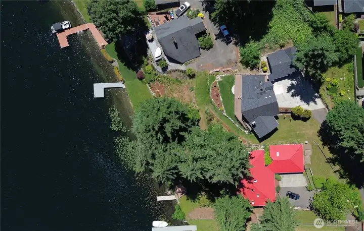 An aerial view showing the full scope of the property, including 85 feet of Lake Meridian waterfront, the large L-shaped dock, over half an acre of beautifully landscaped and terraced grounds, the main home, and the detached 3-car garage. Rare does not begin to cover it.  This home is situated at the quiet end of the lake and has one of the best, most expansive views.