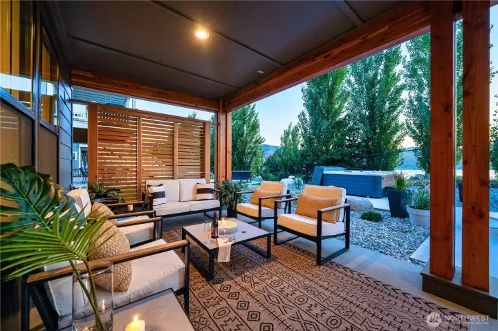 View of outdoor living area lounge area with built-in radiant patio heaters and privacy screens.