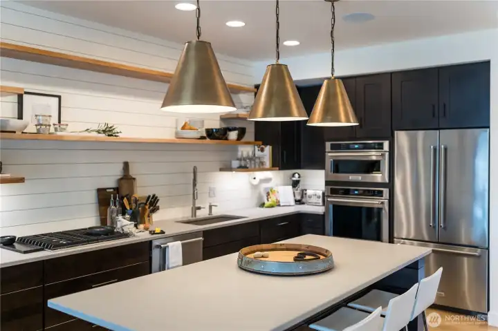 Kitchen with quartz countertops, high-end appliances and sit up island.
