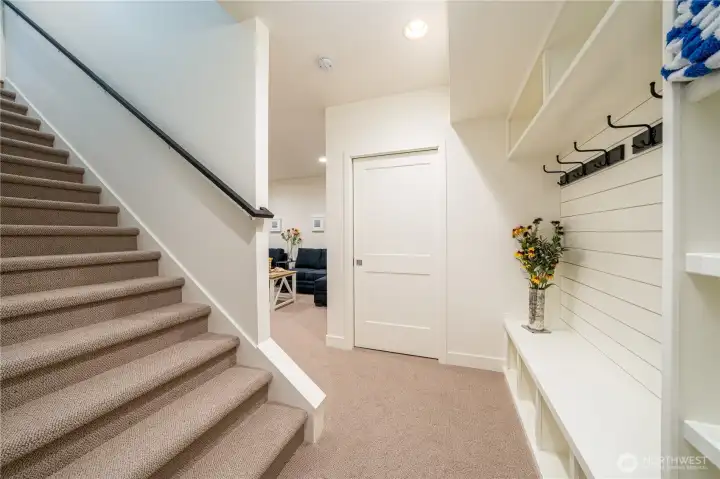Staircase down to the lower level with media room, bunk room and utility room.