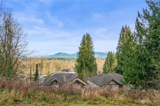 A tighter perspective of the North facing views of Cascade Mountains. The roof of the house on down below off of E Division