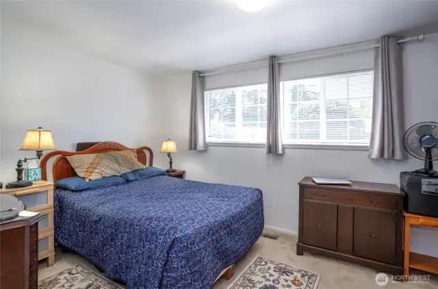 The primary suite boasts two oversized windows that fill the room with natural light.