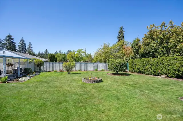 A look at the backyard from the side, showcasing generous space ideal for kids, pets, or backyard games.