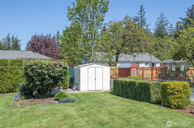 A storage shed tucked at the rear of the backyard adds even more space for tools, equipment, or seasonal items.