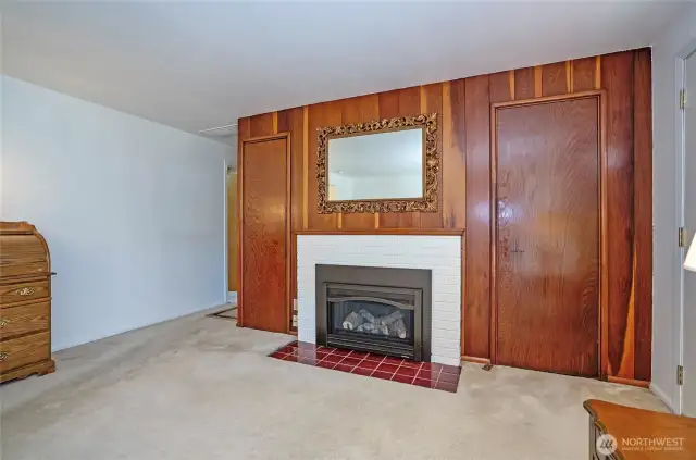 The gas fireplace is a stunning focal point, surrounded by elegant wood trim for a warm, inviting feel.