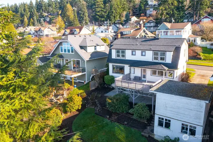 Back of home featuring unique two-story garage/storage building