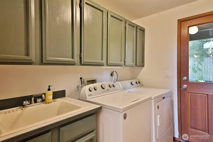 Laundry room on the main hall.  There is a utility sink and the door leads out to the back yard.