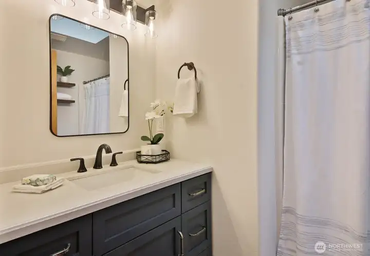 The hall bath is a full bath.  The vanity, lighting and mirror are new.