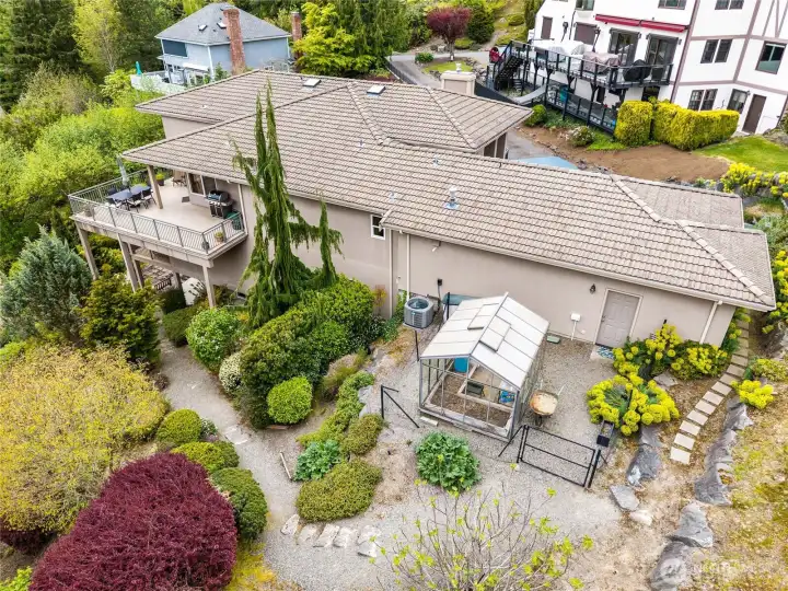 A low maintenance yard with mature landscaping, and a greenhouse for your gardening pleasure.