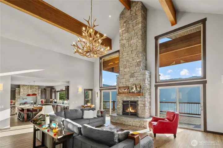 The grand living room offers floor to ceiling views, a custom stone fireplace, soaring ceilings w/ massive beams. Enjoy visiting with others while taking in all this natural beauty inside and outside of the home.