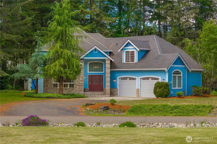 Beautiful custom home on a large corner lot with striking curb appeal and peaceful wooded surroundings.
