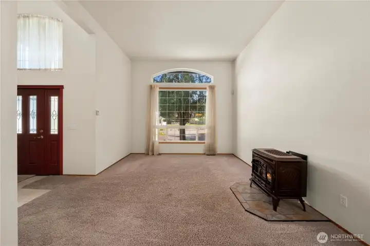 Spacious living area with large picture window, freestanding stove, and flexible layout options