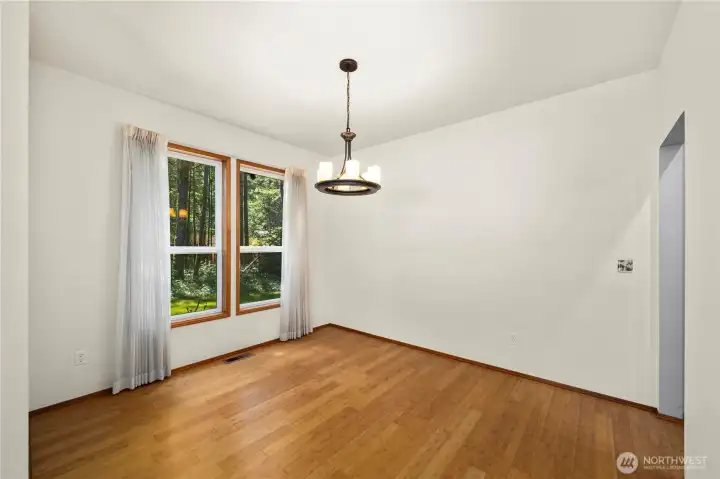 Bright dining area with large windows and beautiful backyard views
