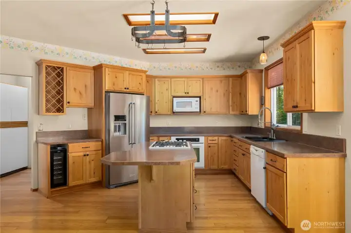 Kitchen featuring stainless appliances, built-in wine storage, and wine fridge