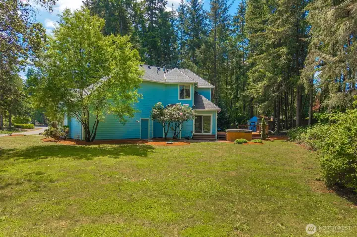 Large backyard with sprinkler system and peaceful park-like setting