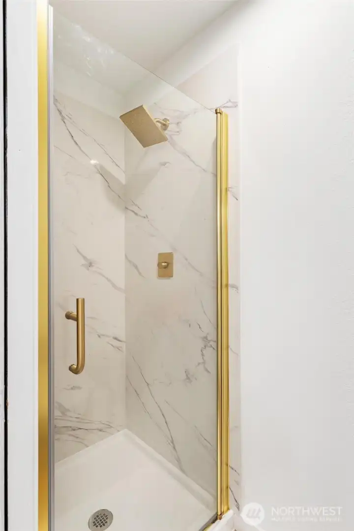 The primary bedroom has a private newly remodeled shower with quartz shower walls, glass door and brushed gold trim. This bathroom also has a heated bidet toilet installed. The primary bedroom has a private newly remodeled shower with quartz shower walls, glass door and brushed gold trim. This bathroom also has a heated bidet toilet installed.