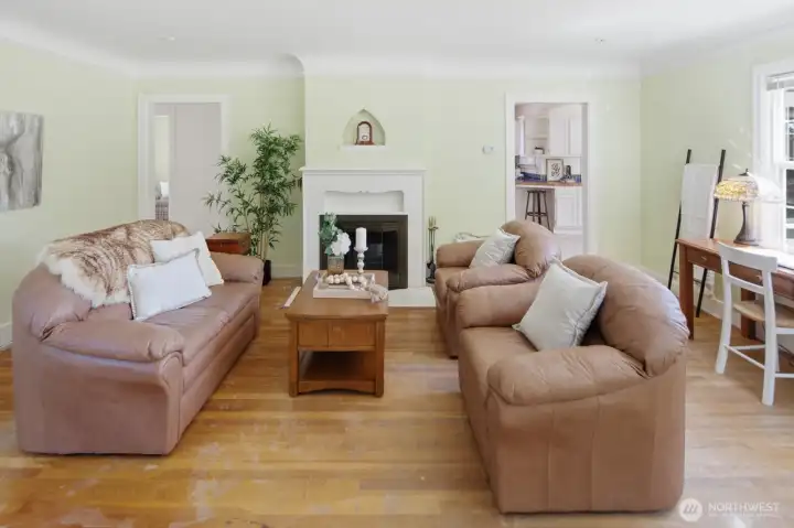 The grand living room offers elegantly coved ceilings, incredible fireplace, and original hardwood floors The grand living room offers elegantly coved ceilings, incredible fireplace, and original hardwood floors