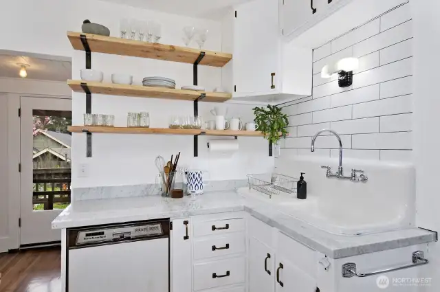 Open shelving- older dishwasher (it is loud but everyone loves it because it washes the dishes spotless in 30 min- they don't make them like they used to!). Open shelving and you can see the back glass door to the deck and yard.The bathroom is just around the corner as well.