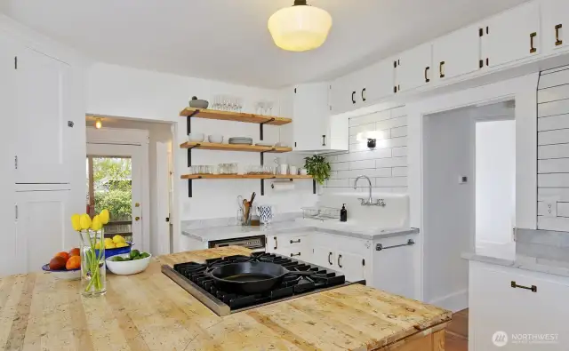 Kitchen was remodeled with butcher block island, gas range, quartz countertops, a vintage farm sink and more!