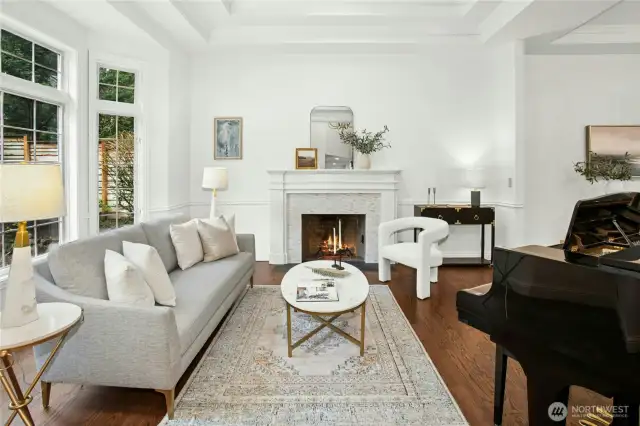 Elegant formal living room with a fireplace, soaring ceilings, and walls of windows -  comfort meets luxury just steps from Beaver Lake.