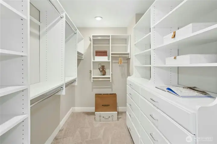 Thoughtfully designed walk-in closet with abundant hanging space, custom shelving, and built-in drawers to keep everything organized and within easy reach.