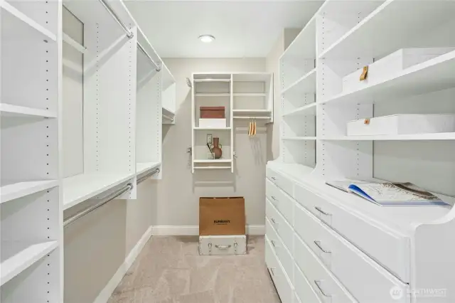 Thoughtfully designed walk-in closet with abundant hanging space, custom shelving, and built-in drawers to keep everything organized and within easy reach.