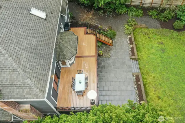 Aerial view of the expansive composite deck and stone patio — perfectly positioned on a shy acre, this 3,960 sq ft home offers seamless indoor-outdoor living surrounded by Pacific Northwest waterfront beauty.