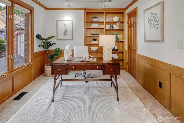 Main level den with built in book shelves and wood wainscoting