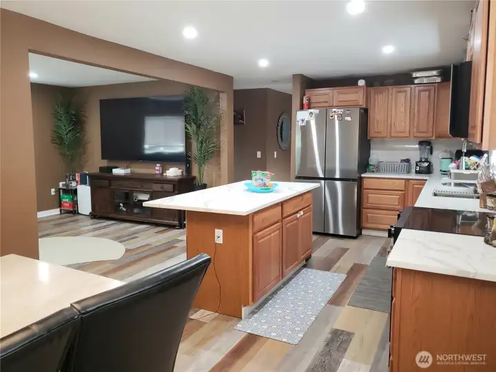 A Different View of the Very Spacious Island Kitchen with New Granite Counter Tops, Sink, Faucet, Stainless Appliances, Real Solid Oak Cabinets, LED Lighting, Paint,Trim, and Vinyl Plan Flooring Showing Dining Room.