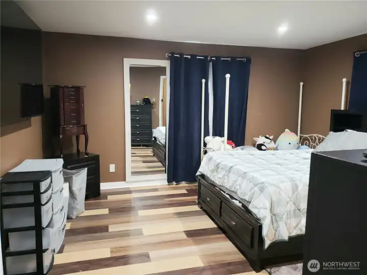 An Opposite View of the Primary Master Bedroom Showing New Paint, Trim Led Lighting and Vinyl Plank Flooring.