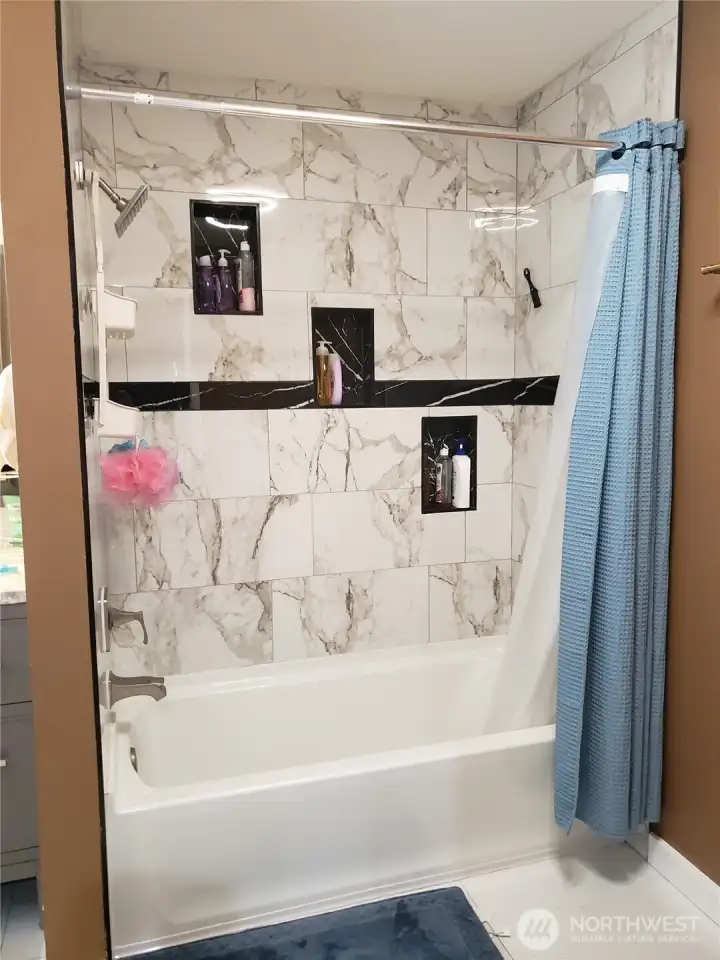 Full View of the Main Gust Bath Tub and Floor to Ceiling Tile Surround and Tile Flooring.
