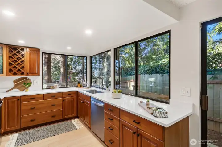 The newly refreshed kitchen features LVP flooring, cherry cabinets, crushed quartz counters with new stainless undermount sink and faucet.