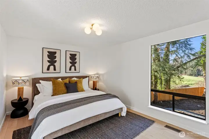 The primary suite overlooks the private grounds and features new flooring and lighting.