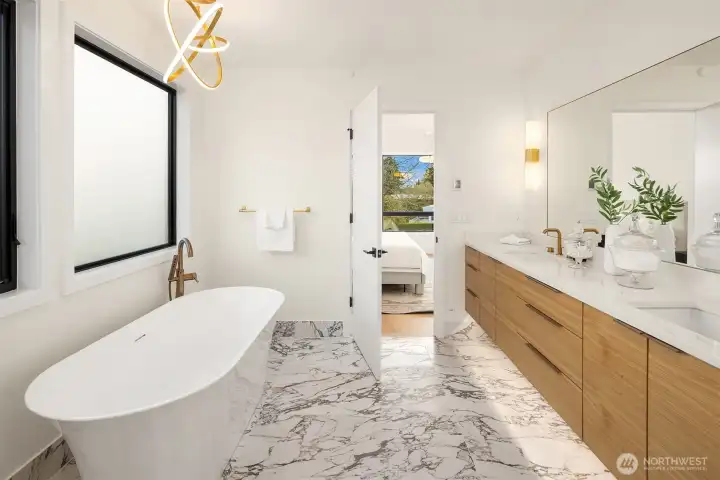 A spa-inspired bath featuring a curbless shower and marble tile.