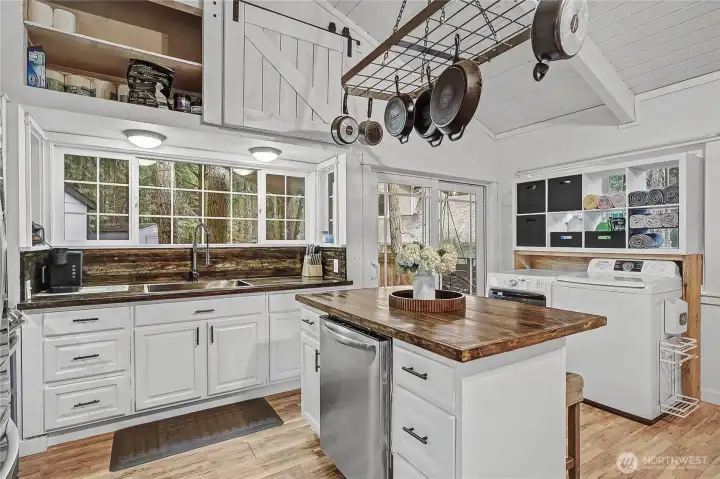 As you enter the cabin, from the front door or the sliding patio doors, you will find an open-concept living and dining space. I love the refinished counters and tall cathedral ceilings with extra storage, just adorable!