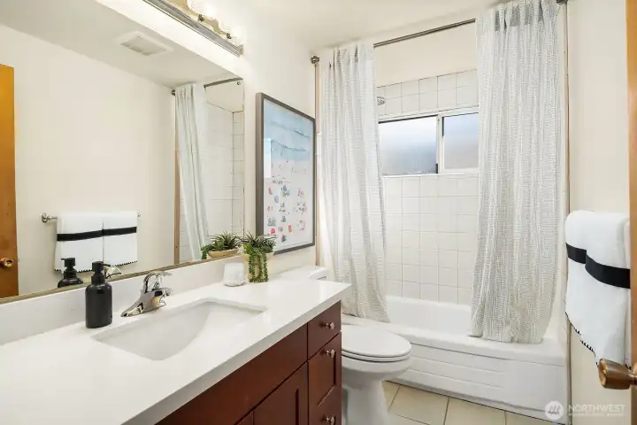 Quartz countertop and undermount sink in the full bathroom with tub and shower combo.