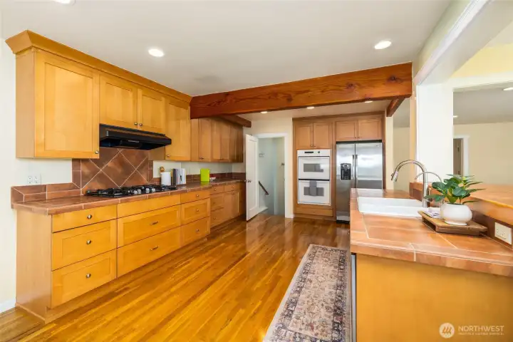 Kitchen has hardwood floors and newer appliances. Door in the background is the access to the daylit and finished basement.