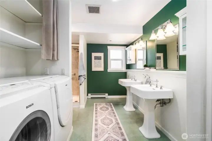 Primary bathroom with two sinks and the laundry area.